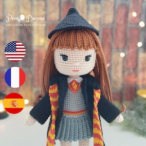 Könnte beinhalten: Gehäkelte Amigurumi-Puppe mit braunen Haaren, einem schwarzen Gewand und einem rot-gelben Schal. Die Puppe trägt einen grauen Rock und einen schwarzen Hut. Die Puppe steht vor einer Backsteinmauer.