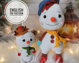 May include: Two crocheted snowman amigurumi toys. The larger snowman is wearing a blue beret, a yellow scarf, and red boots. The smaller snowman is wearing a brown hat with red berries, a green scarf, and red mittens. Both snowmen have white bodies, black eyes, and orange noses.