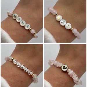 May include: Four bracelets with pink and white beads. The bracelets feature gold letters spelling out "MAMA", "NAN", "MOMMY", and a heart.