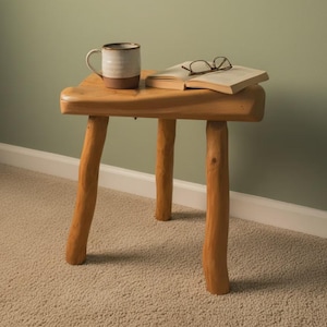 May include: A white ceramic mug with a black handle and the text "But First, Coffee" in a black, bold font. The mug is sitting on a wooden surface. The mug is approximately 4 inches tall.