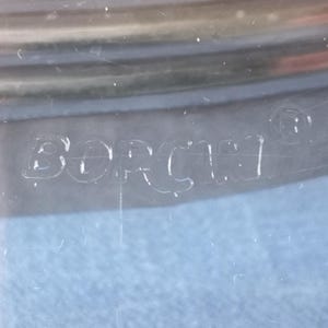 May include: Close-up of a clear glass container with the word "Borner" etched into the bottom.