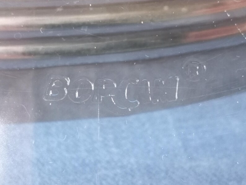May include: Close-up of a clear glass container with the word "Borner" etched into the bottom.