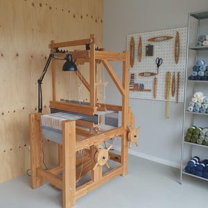 Zabytkowe szwedzkie krosno tkackie z drewnianą podłogą i lampą, profesjonalny warsztat tkacki.