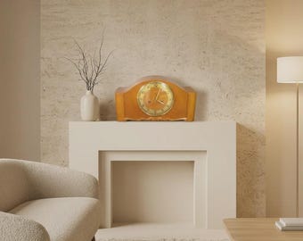 May include: A wooden mantel clock with a curved top and a gold-toned circular face featuring black numerals and hands. The clock has a polished finish and a smooth, arched silhouette, presenting a classic timekeeping design for a flat surface.