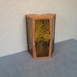 May include: A hexagonal copper-colored lampshade with a textured glass panel. The glass is a mottled green and brown color.