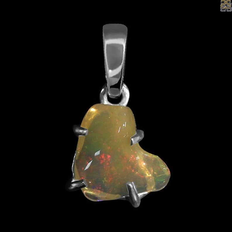 May include: A silver heart-shaped pendant with a yellow opal gemstone. The opal has a rainbow of colors.