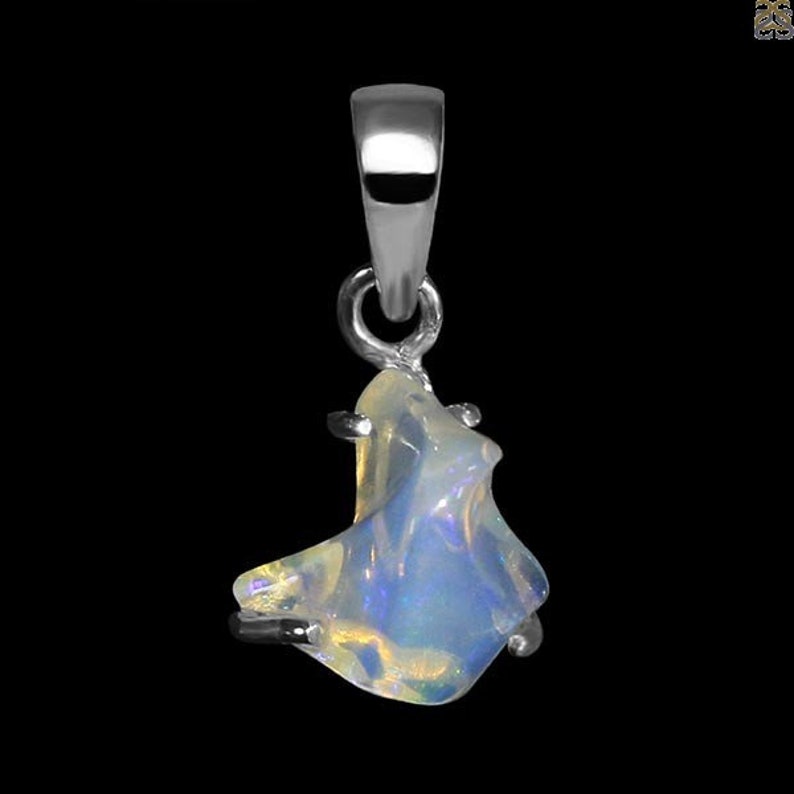 May include: A silver pendant featuring a white opal gemstone with a unique, irregular shape. The opal has a shimmering, iridescent quality.