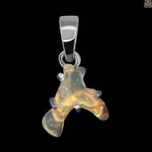 May include: A silver pendant featuring a raw, iridescent opal gemstone. The opal is a natural, irregular shape with a rough, textured surface. The pendant is designed to be worn on a chain or cord.