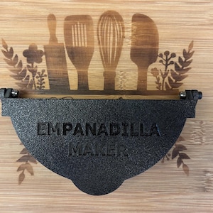 May include: Black plastic empanada maker with the text "Empanadillo Maker" printed on the front.
