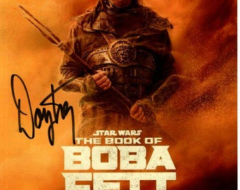 May include: A promotional poster for the Star Wars series "The Book of Boba Fett" featuring Temuera Morrison as Boba Fett. The poster has a red, orange, and yellow color scheme with a desert background. The text "STAR WARS THE BOOK OF BOBA FETT" is in white and the Disney+ logo is in the bottom right corner.