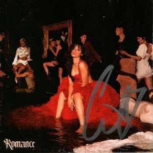 Puede incluir: Una mujer con un vestido rojo se sienta en una habitación inundada con un grupo de personas en el fondo. La habitación está tenuemente iluminada y las paredes son oscuras. La mujer mira a la cámara y su firma es visible en la esquina inferior derecha. El texto "Romance" es visible en la esquina inferior izquierda.