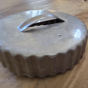 May include: A silver metal pie crust cutter with a fluted edge and a handle. The cutter has a smooth, shiny surface.