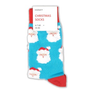 Puede incluir: Calcetines azules con un patrón de Papá Noel blanco. Los calcetines tienen ribetes rojos y una etiqueta que dice "HOMY CHRISTMAS SOCKS 4-7 UK 35-40".