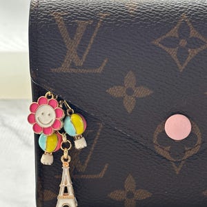 Globos pastel con temática de París, flores y Torre Eiffel. Cartera, neceser y mini charm.