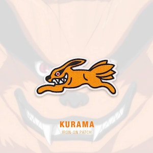 Op de afbeelding: Oranje en witte strijkpatch met een cartoonvos met rode ogen en een brede grijns. De tekst "KURAMA IRON-ON PATCH" staat onder de vos.