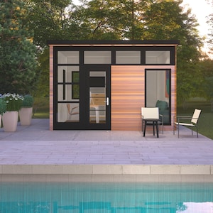 May include: A contemporary wooden cabin with black window frames and a door. The building has large windows and a door, with two chairs and a small table outside. The scene is set near a pool with potted plants in the background.
