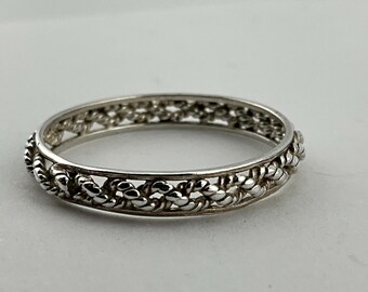 May include: A silver ring with a braided design. The band is thin and the braid is intricate.