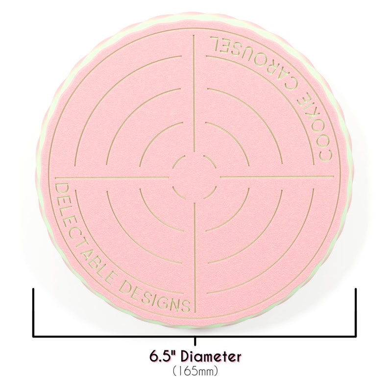 Op de afbeelding: Een roze en groene koekjescarrousel met een diameter van 16,5 cm. De carrousel is ontworpen om koekjes te bewaren en heeft een cirkelvormig ontwerp met concentrische cirkels. De tekst "Cookie Carousel" en "Delectable Designs" staat op de carrousel gedrukt.