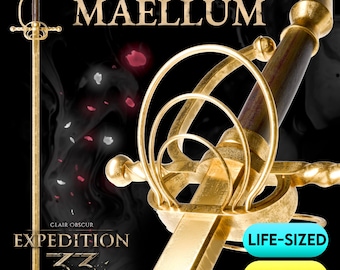 May include: A gold-colored sword with a brown handle. The sword has a complex hilt design and a long, slender blade. The text "MAELE'S SWORD MAELLUM" is at the top, with "EXPEDITION 33" at the bottom. The words "LIFE-SIZED" and "STL FILES" are also visible.