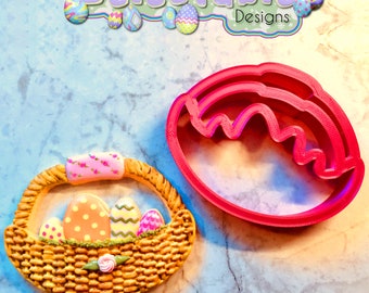 May include: A red plastic cookie cutter shaped like an Easter egg, and a decorated cookie shaped like a basket with Easter eggs inside.  Delectable Designs.