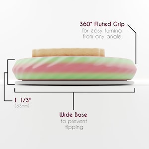 Op de afbeelding: Een ronde, veelkleurige taartstandaard met een geribbelde rand en een brede basis. De standaard is 3,3 cm (1 1/3 inch) hoog. De tekst "360&deg; Fluted Grip for easy turning from any angle" en "Wide Base to prevent tipping" staat op de afbeelding.