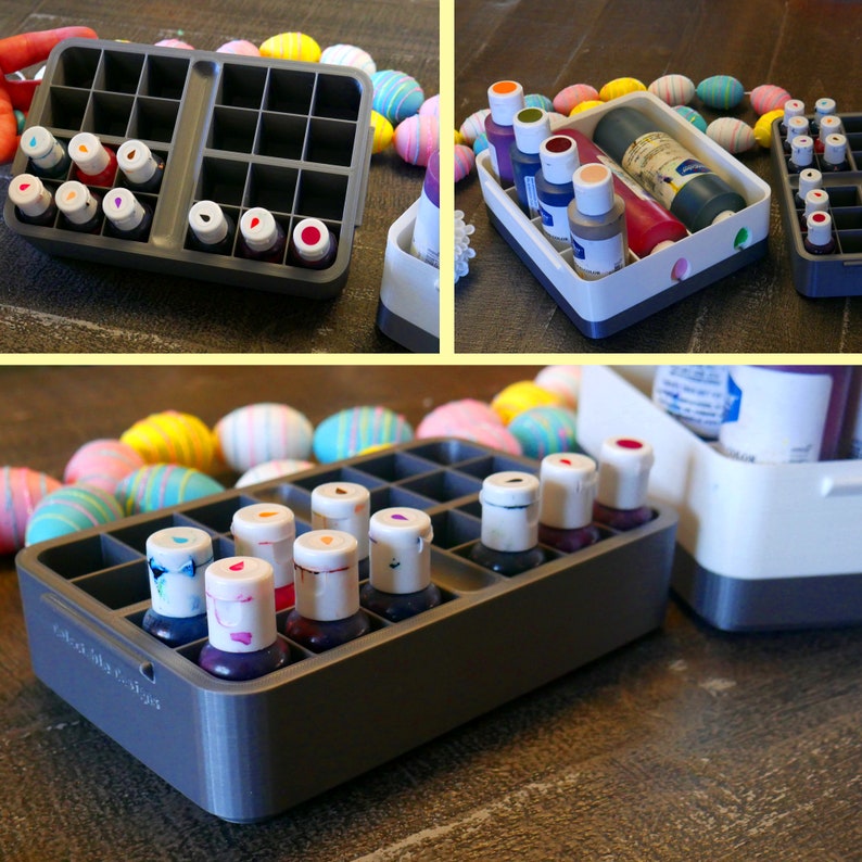 May include: A gray plastic container with 24 compartments for holding small bottles of liquid food coloring. The container is filled with colorful bottles of food coloring. The container is sitting on a wooden table.