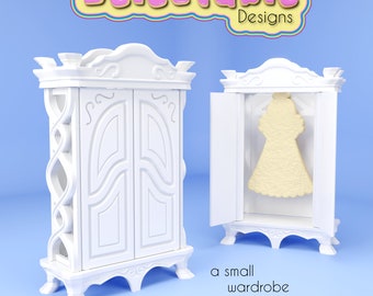 May include: A white, ornate, two-door cabinet with a cookie shaped like a dress inside. The cabinet is labeled "Delectable Designs" and the text "a small wardrobe for cookies" is below the cabinet.