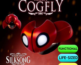 May include: A red and black Cogfly prop from the Hollow Knight: Silksong video game, with white eye details. The image includes the text "Hornet's Cogfly", "Functional", "Life-Sized", and "STL Files".