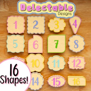 May include: A set of 16 cookie cutters in various shapes, numbered 1 through 16. The cutters are made of a light yellow material with a white outline and are arranged on a wooden surface. The text "Delectable Designs" is at the top of the image.
