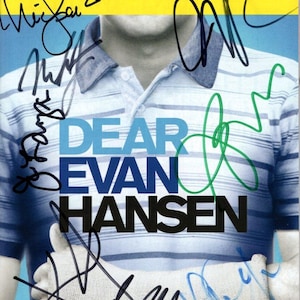 Puede incluir: Una portada de Playbill para "Dear Evan Hansen" con la parte superior amarilla y la inferior azul. El título está en letras grandes y en negrita. La imagen presenta a una persona con una camisa a rayas y un yeso en el brazo. La portada está firmada por varias personas.