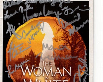 Kobieta w bieli podpisała program z autografem obsady