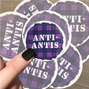 May include: A set of six purple and white gingham coasters with the text "ANTI-ANTIS" printed on each one.