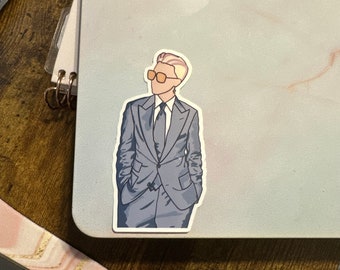 May include: A sticker of a person wearing a gray suit, a white shirt, a black tie, and orange sunglasses. The person has short blonde hair.