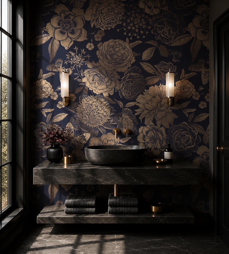 May include: A bathroom vanity area featuring a dark marble countertop with a black vessel sink, gold wall-mounted faucet, and two ribbed glass wall sconces. The wall is covered in dark navy wallpaper with a gold floral and butterfly pattern.
