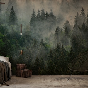 May include: A forest-themed mural dominates the wall, depicting a misty, green forest with tall trees. The room features a bed with a brown blanket, wooden stools, and a modern chair. A shelf displays decorative items.