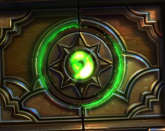 Puede incluir: Un cofre del tesoro de madera con un diseño circular verde brillante en la parte delantera. El diseño presenta un patrón de estrella con un orbe verde brillante en el centro.