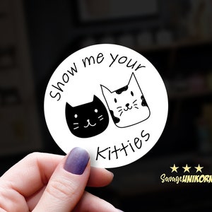 May include: White round sticker with black text that says "Show me your kitties". Two black and white cartoon cats are on the sticker.