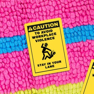 May include: A yellow sign with black text and a graphic of two figures in a fight. The sign reads "CAUTION TO AVOID WORKPLACE VIOLENCE STAY IN YOUR LANE." The sign is on a pink, blue, and green textured background.