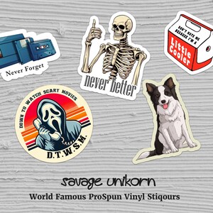 May include: Five vinyl stickers with various designs. One sticker features a cassette tape and a VHS tape with the text "Never Forget". Another sticker features a skeleton with the text "never better". A third sticker features a cartoon ghost with a phone and the text "Down to watch scary movies D.T.W.S.M.". A fourth sticker features a cartoon dog with the text "savage unikorn World Famous ProSpun Vinyl Stiqours". The last sticker features a red cooler with the text "Don't hate me because I'm a Little Cooler".