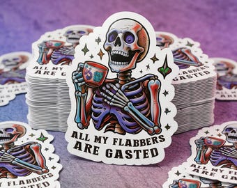 May include: A stack of white stickers featuring a colorful skeleton holding a teacup. The skeleton is depicted with red, purple, and blue hues. The text "ALL MY FLABBERS ARE GASTED" is printed on the sticker in black.