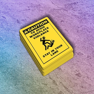 May include: A stack of yellow rectangular signs with black text and graphics. The top sign reads "CAUTION TO AVOID WORKPLACE VIOLENCE" with a graphic of two figures. The bottom text reads "STAY IN YOUR LANE".