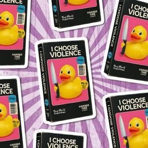 May include: Sticker featuring a yellow rubber duck holding a knife, set against a pink background. The sticker reads "I Choose Violence" with "Comedy" and "PG-13" labels. The design is repeated across a purple and white striped background.