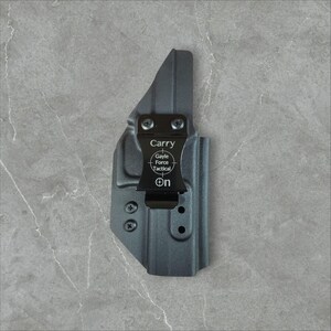 K&ouml;nnte beinhalten: Eine schwarze Holster mit einem Metallclip. Auf dem Clip steht oben das Wort "Carry", darunter "Gayle Force Tactical" und "ON". Die Holster ist f&uuml;r das Tragen am K&ouml;rper konzipiert.