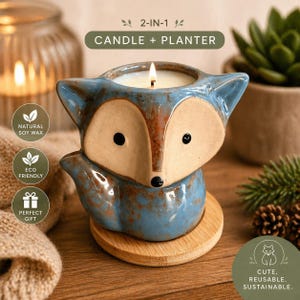 May include: A blue and tan fox-shaped candle and planter. The candle is lit, and the planter is on a wooden base. The text on the image says "2-IN-1 CANDLE + PLANTER", "NATURAL SOY WAX", "ECO FRIENDLY", and "PERFECT GIFT".