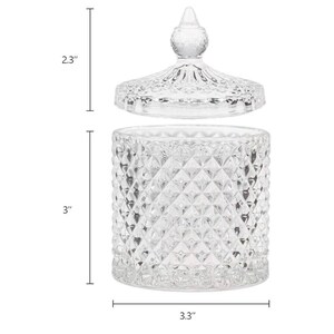 May include: A clear glass jar with a lid, featuring a diamond pattern. The jar is 3 inches tall and 3.3 inches wide. The lid is 2.3 inches tall. The jar is designed to hold small items and has a decorative appearance.