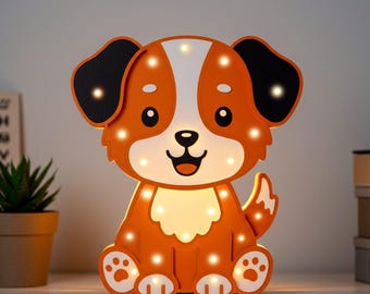 Könnte beinhalten: Orangefarbenes und weißes Holz-Nachtlicht in Form eines Cartoon-Hundes mit einem lächelnden Gesicht. Der Hund hat schwarze Ohren und einen Schwanz. Das Nachtlicht hat kleine weiße LED-Leuchten um den Körper des Hundes herum.
