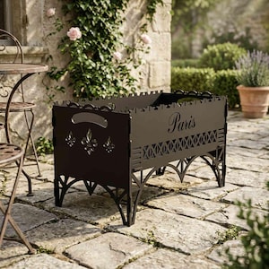 Puede incluir: Un brasero de metal marrón oscuro con la palabra "Paris" en el lateral. El brasero tiene cortes decorativos y diseños de flor de lis. Tiene forma rectangular con patas arqueadas y asas.