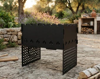 Op de afbeelding: Een draagbare barbecue van zwart metaal met een rechthoekige vuurkorf, voorzien van lasergesneden vlammotieven aan de zijkanten en een ruitvormig roosterpatroon op de poten. De bovenrand heeft inkepingen voor het plaatsen van spiesen.