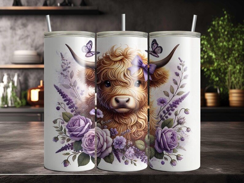 May include: A white stainless steel tumbler with a design of a Highland cow with purple flowers and butterflies. The cow has a purple bow on its head.
