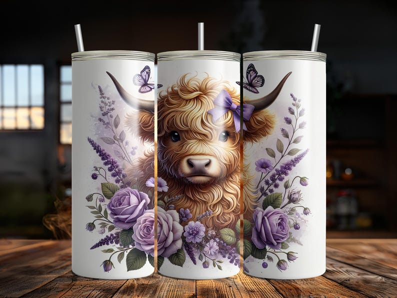 May include: A white stainless steel tumbler with a purple floral design and a Highland cow with a purple bow. The cow is brown and white with a fluffy mane.
